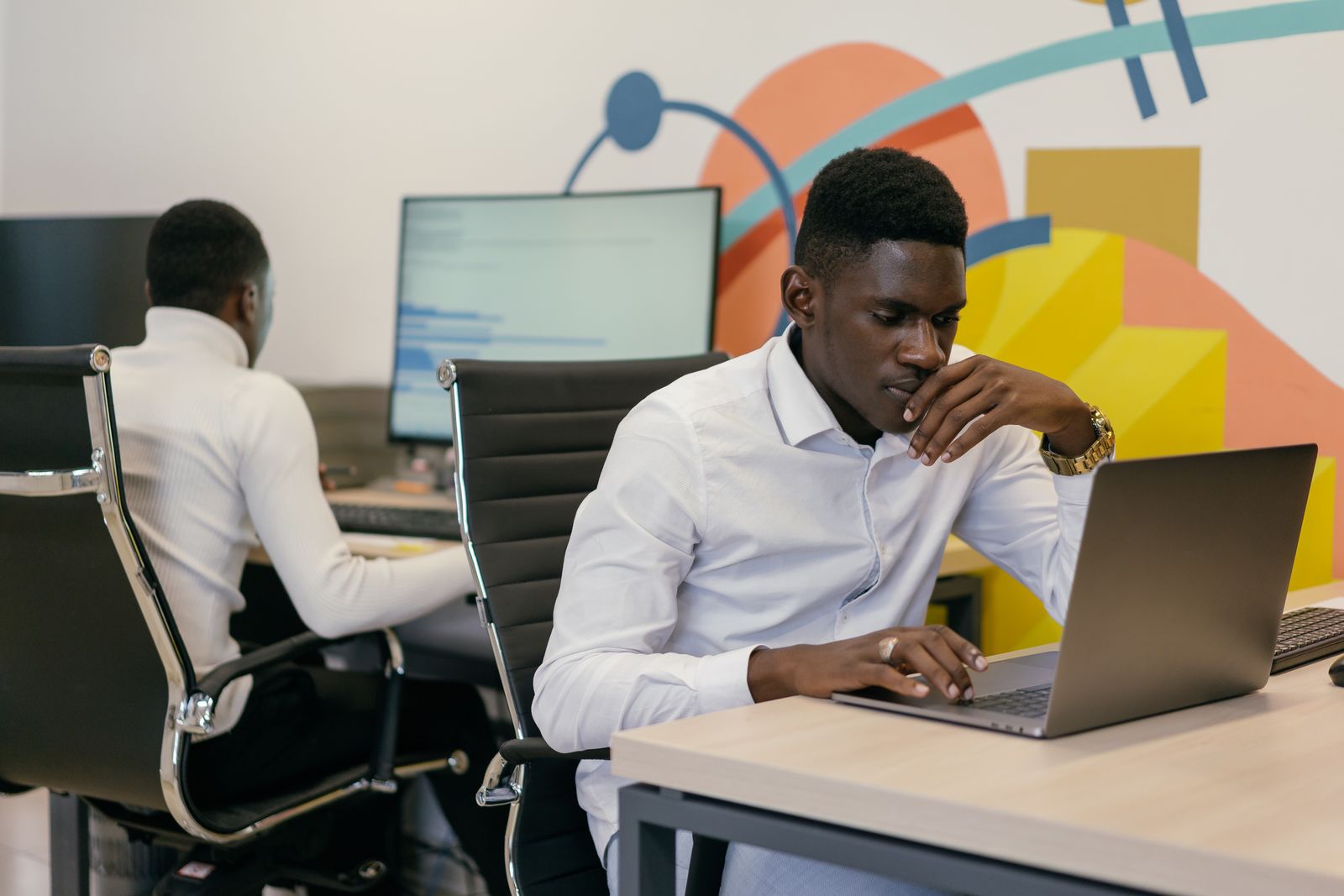 ICT professionals working on laptops in a modern office